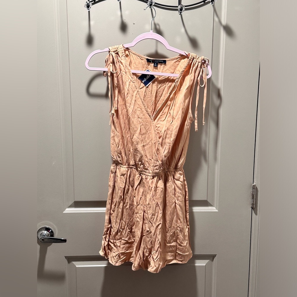 New nude short romper with tags attached